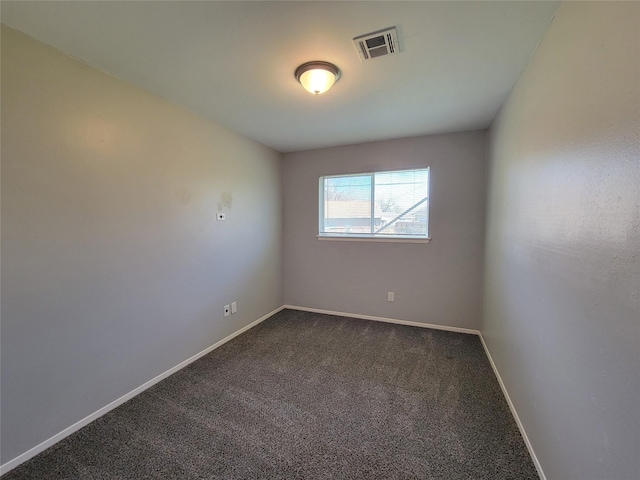 empty room with dark colored carpet and baseboards