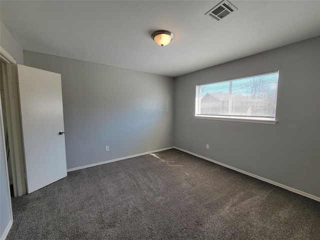 carpeted empty room featuring baseboards