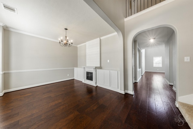 3722 Rocky Ledge Ln, Katy, TX 77494 - unfurnished living room with arched walkways, dark wood-style floors, a chandelier, ornamental molding, and a glass covered fireplace