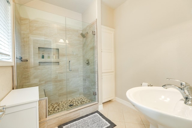 54 Scotch Pine Ct, Lake Jackson, TX 77566 - bathroom featuring a sink, tile patterned floors, a shower stall, and baseboards