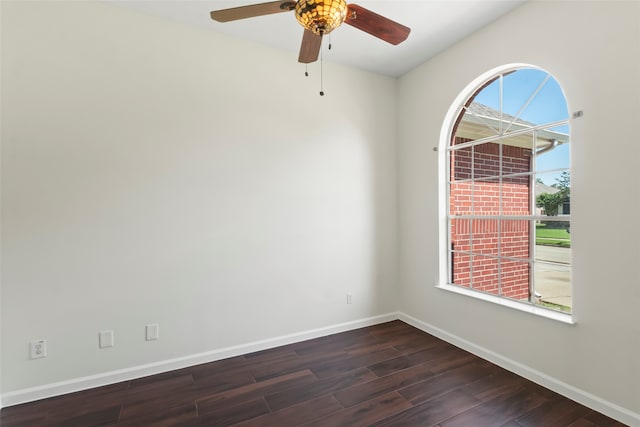 unfurnished room featuring baseboards, dark wood-style floors, and ceiling fan