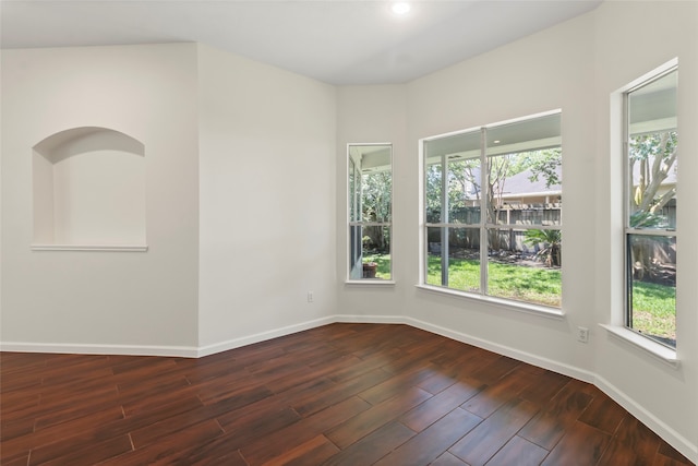 empty room featuring baseboards, dark wood-style flooring, and recessed lighting