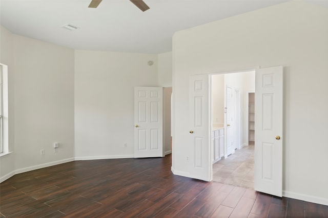 empty room with dark wood-style floors, ceiling fan, and baseboards