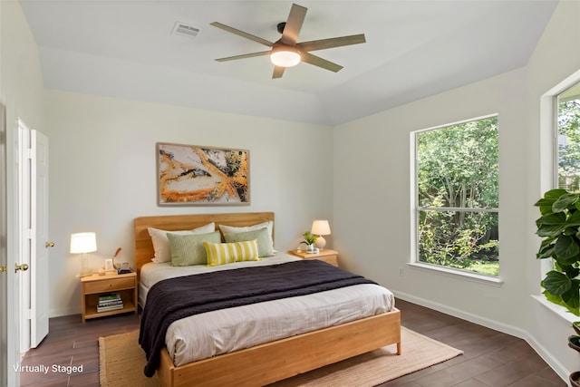 bedroom with dark wood-type flooring, baseboards, and ceiling fan