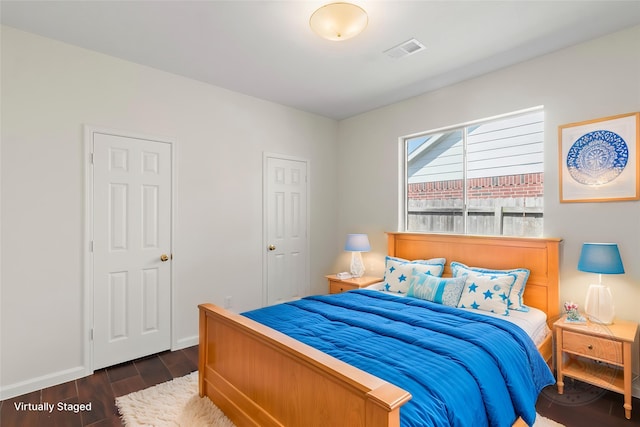 bedroom featuring dark wood finished floors and baseboards
