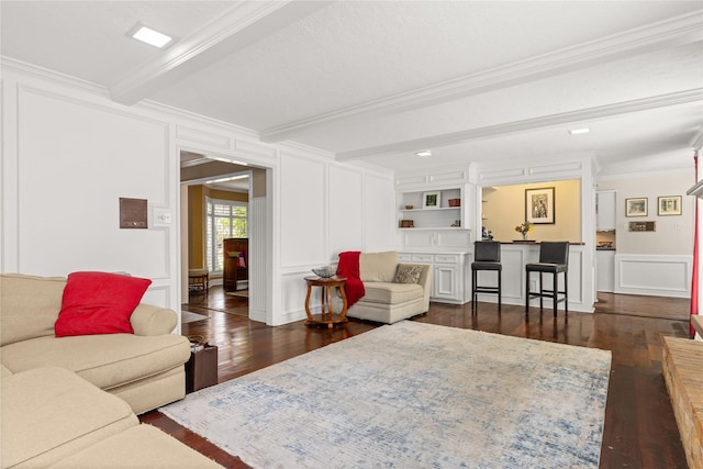 living area featuring a decorative wall, ornamental molding, dark wood finished floors, and beam ceiling