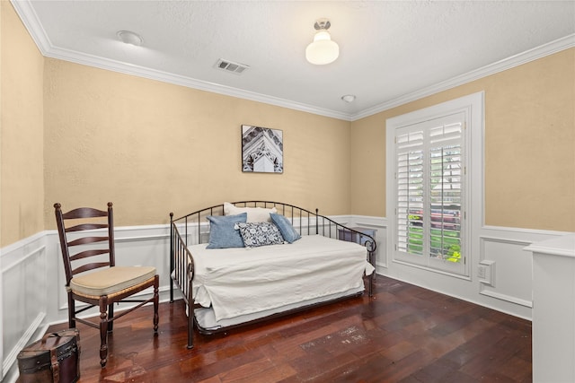 bedroom with wood-type flooring, crown molding, wainscoting, and a textured ceiling