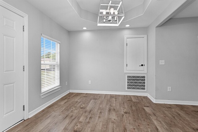 1107 Cypress St, Diboll, TX 75941 - spare room with a tray ceiling, wood finished floors, a chandelier, recessed lighting, and baseboards