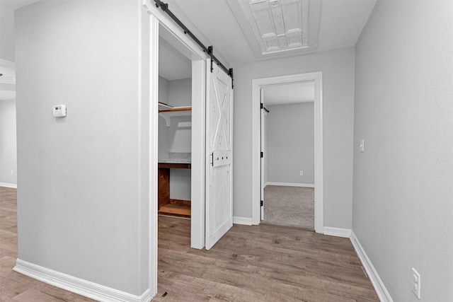 1107 Cypress St, Diboll, TX 75941 - corridor with a barn door, wood finished floors, and baseboards