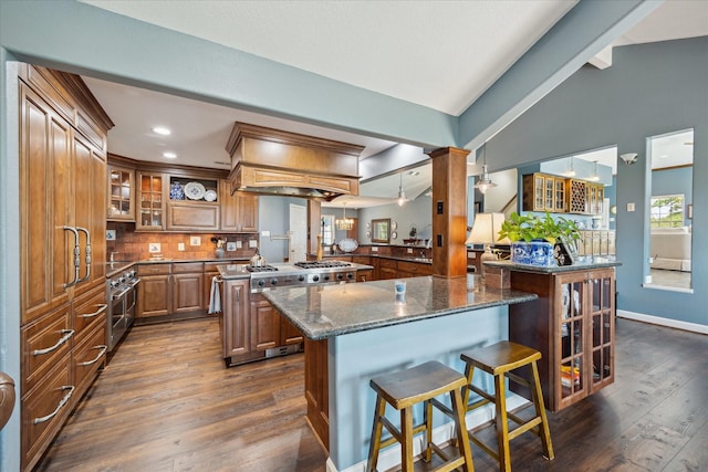 3814 Todville Rd, Seabrook, TX 77586 - kitchen with brown cabinets, a breakfast bar area, dark wood-type flooring, glass insert cabinets, and a center island