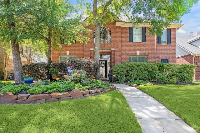 colonial home with a front lawn and brick siding