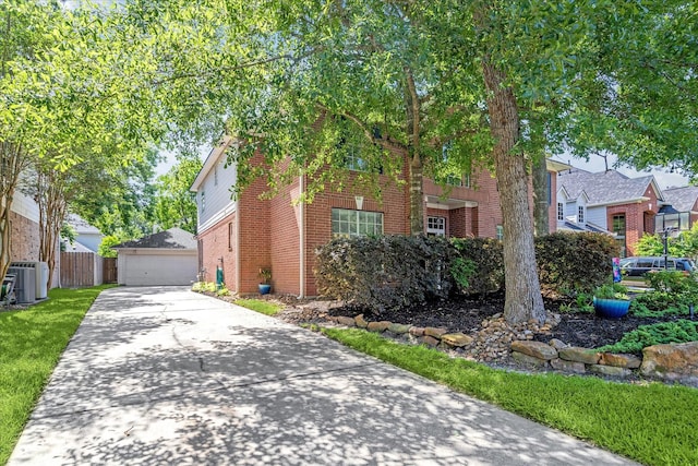 view of front of home with brick siding, fence, and a detached garage