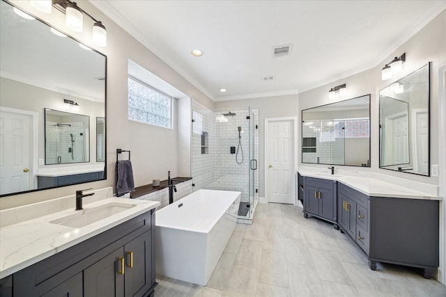 full bathroom featuring a stall shower, a freestanding bath, two vanities, crown molding, and recessed lighting