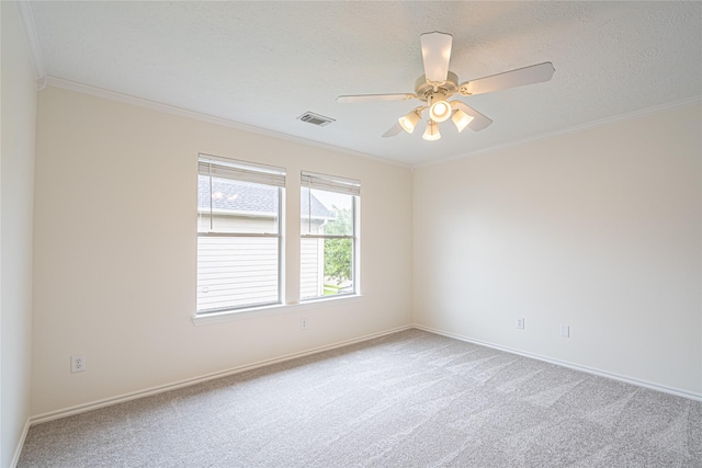 carpeted spare room featuring ornamental molding, baseboards, ceiling fan, and a textured ceiling