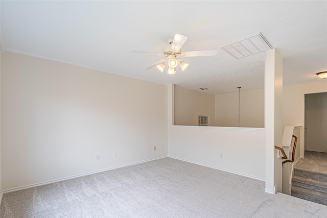carpeted spare room featuring a ceiling fan and baseboards