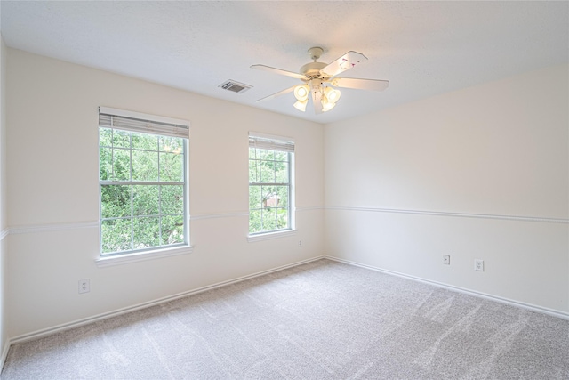 carpeted spare room with ceiling fan and baseboards