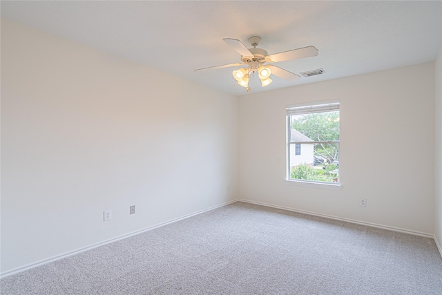 carpeted empty room featuring baseboards and a ceiling fan