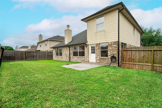 rear view of property with a patio area, brick siding, roof with shingles, and a chimney