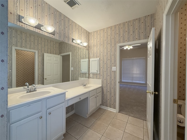 bathroom featuring tile patterned floors, wallpapered walls, double vanity, and baseboards
