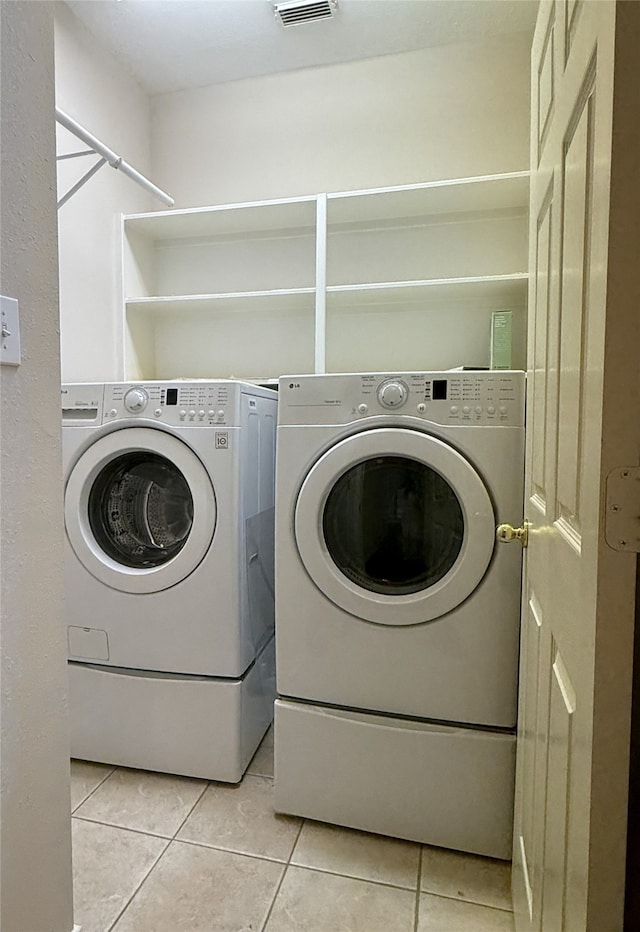 washroom featuring independent washer and dryer and light tile patterned floors