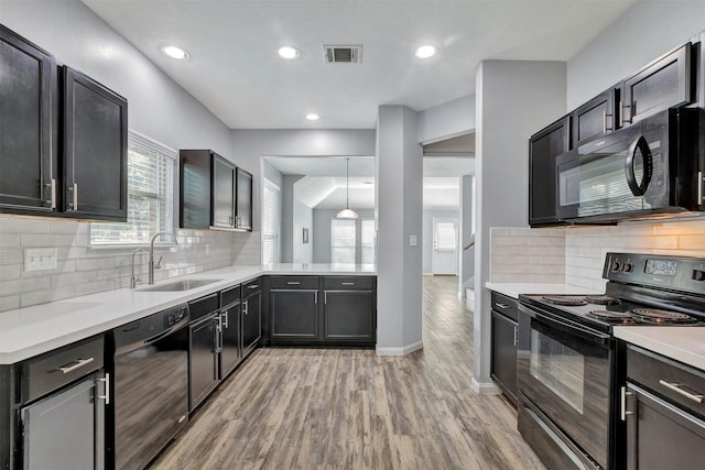 3807 Springcrest Ln, Montgomery, TX 77356 - kitchen with black appliances, a sink, light wood-type flooring, healthy amount of natural light, and recessed lighting