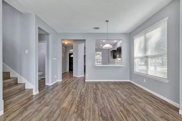 3807 Springcrest Ln, Montgomery, TX 77356 - unfurnished dining area featuring dark wood-style flooring, baseboards, plenty of natural light, and stairs