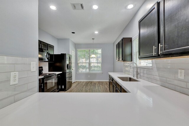 3807 Springcrest Ln, Montgomery, TX 77356 - kitchen with black appliances, a sink, light countertops, light wood-style floors, and backsplash