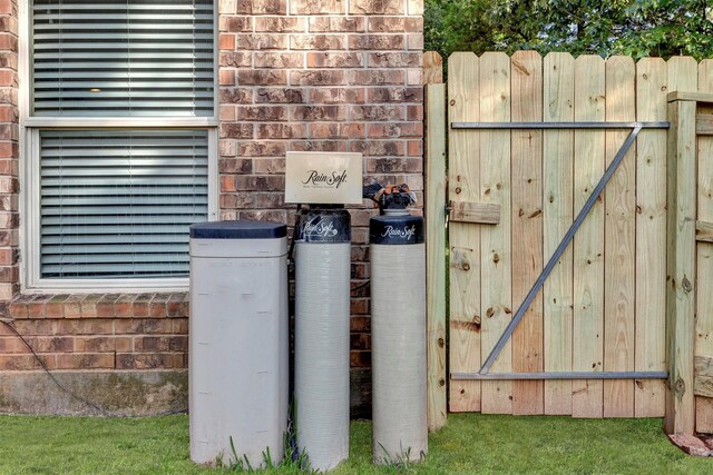 3807 Springcrest Ln, Montgomery, TX 77356 - exterior view of fence, brick siding, a gate, and a water softener system