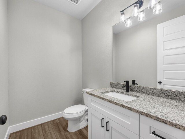 1462 Rd 66114, Dayton, TX 77535 - half bath featuring wood finished floors, vanity, baseboards, and toilet