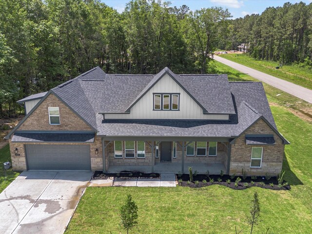 1462 Rd 66114, Dayton, TX 77535 - view of front of property with a shingled roof, stone siding, board and batten siding, driveway, and a front lawn