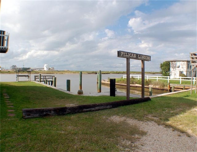 dock area with a lawn and a water view