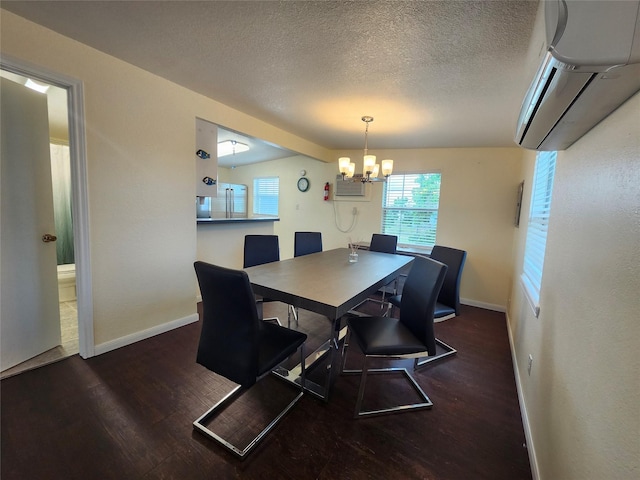 dining space featuring wood finished floors, a wall unit AC, a chandelier, baseboards, and a textured ceiling
