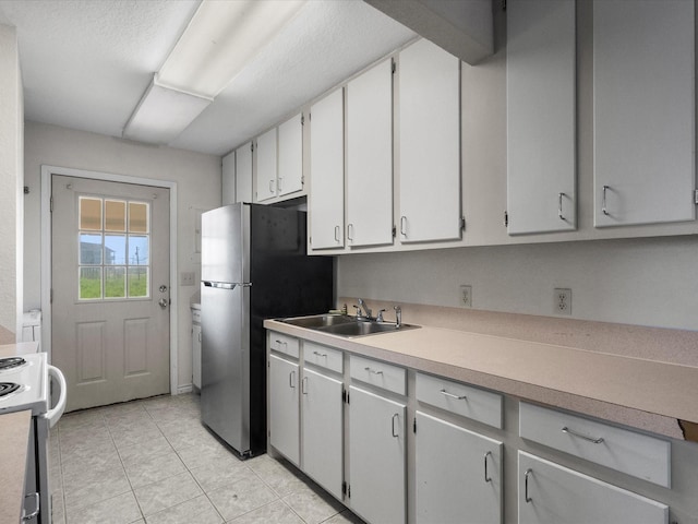 1134 Canal Dr, Surfside Beach, TX 77541 - kitchen with stove, light countertops, and light tile patterned flooring