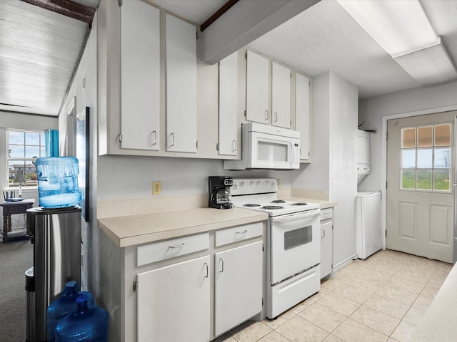 1134 Canal Dr, Surfside Beach, TX 77541 - kitchen with white appliances, stacked washer / dryer, light countertops, and plenty of natural light