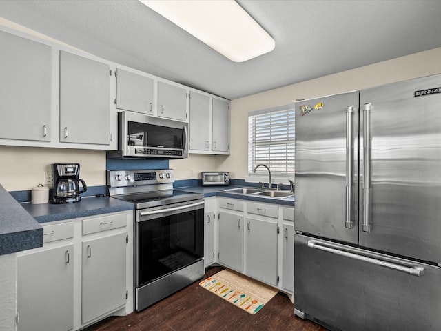 1134 Canal Dr, Surfside Beach, TX 77541 - kitchen with appliances with stainless steel finishes, dark countertops, and dark wood-style flooring