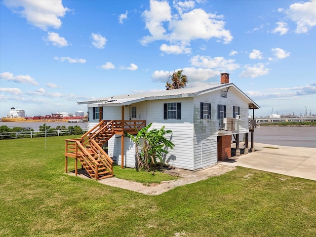 1134 Canal Dr, Surfside Beach, TX 77541 - view of front of home with stairway, a wooden deck, a chimney, and concrete driveway