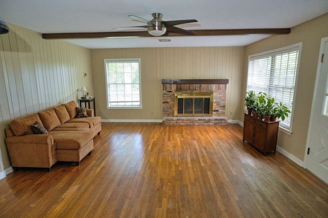 524 Oak Dr, Lake Jackson, TX 77566 - living room with beamed ceiling, wood finished floors, ceiling fan, baseboards, and a brick fireplace