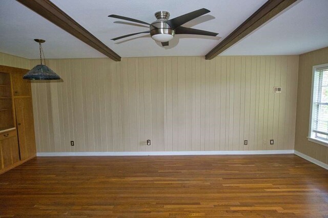 524 Oak Dr, Lake Jackson, TX 77566 - empty room featuring beamed ceiling, wood finished floors, ceiling fan, plenty of natural light, and wood walls