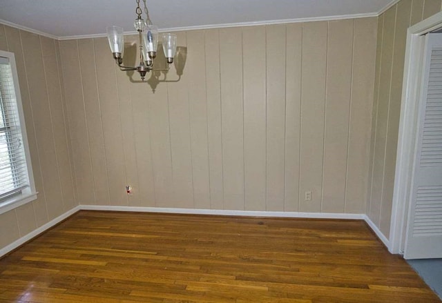 524 Oak Dr, Lake Jackson, TX 77566 - unfurnished dining area with a chandelier, hardwood / wood-style floors, baseboards, crown molding, and wooden walls