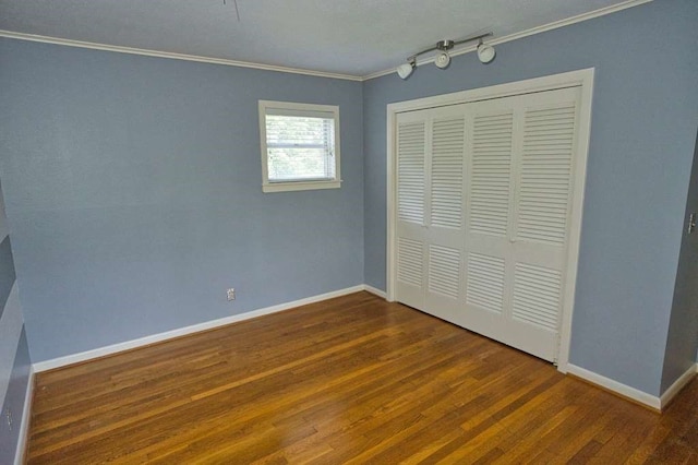 524 Oak Dr, Lake Jackson, TX 77566 - unfurnished bedroom featuring crown molding, wood finished floors, baseboards, and a closet