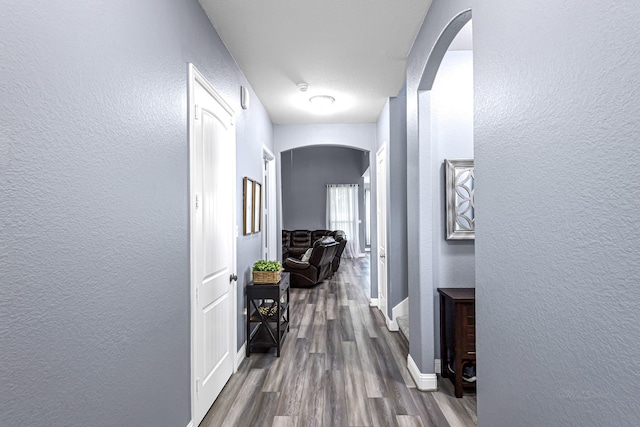 4302 Stoney Heights Ct, Spring, TX 77388 - corridor featuring arched walkways, dark wood finished floors, a textured wall, and baseboards