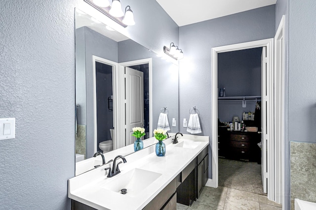 4302 Stoney Heights Ct, Spring, TX 77388 - full bathroom with a textured wall, toilet, tile patterned flooring, and double vanity