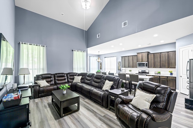4302 Stoney Heights Ct, Spring, TX 77388 - living room featuring high vaulted ceiling, light wood-style flooring, and a chandelier