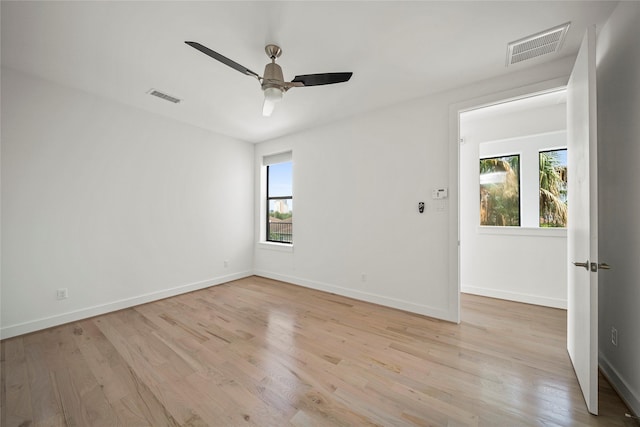 unfurnished room featuring plenty of natural light, light wood-type flooring, and a ceiling fan