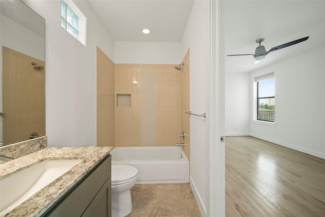 bathroom featuring  shower combination, toilet, vanity, ceiling fan, and wood finished floors