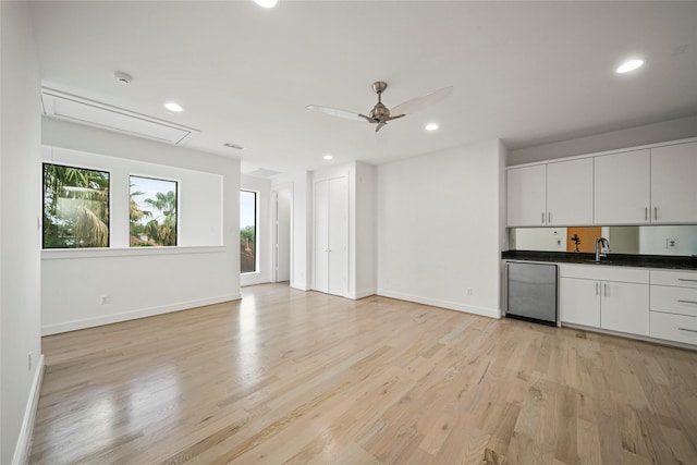 kitchen featuring light wood-type flooring, dark countertops, baseboards, and recessed lighting