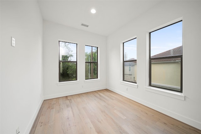 spare room with baseboards, wood finished floors, and recessed lighting