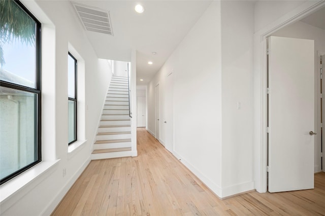 hallway with recessed lighting, light wood-style flooring, stairway, and baseboards
