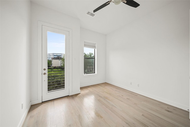 unfurnished room with light wood-style flooring, a ceiling fan, and baseboards