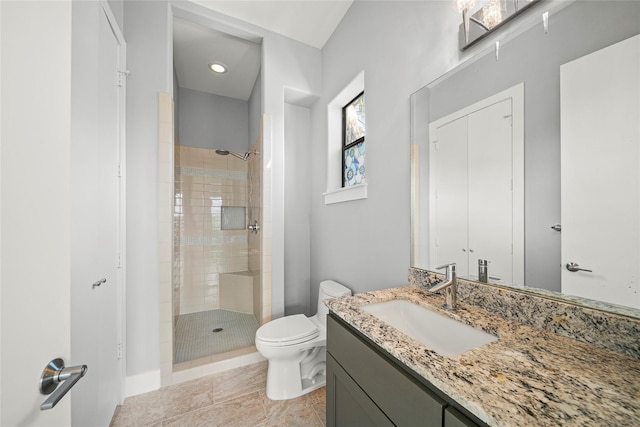 bathroom featuring a stall shower, toilet, and vanity
